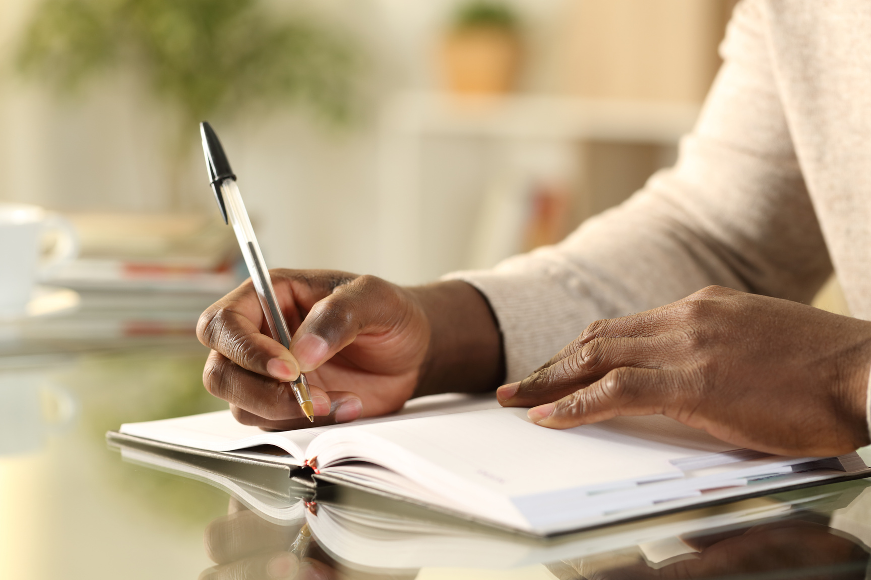 Black man hands writing reminder on agenda